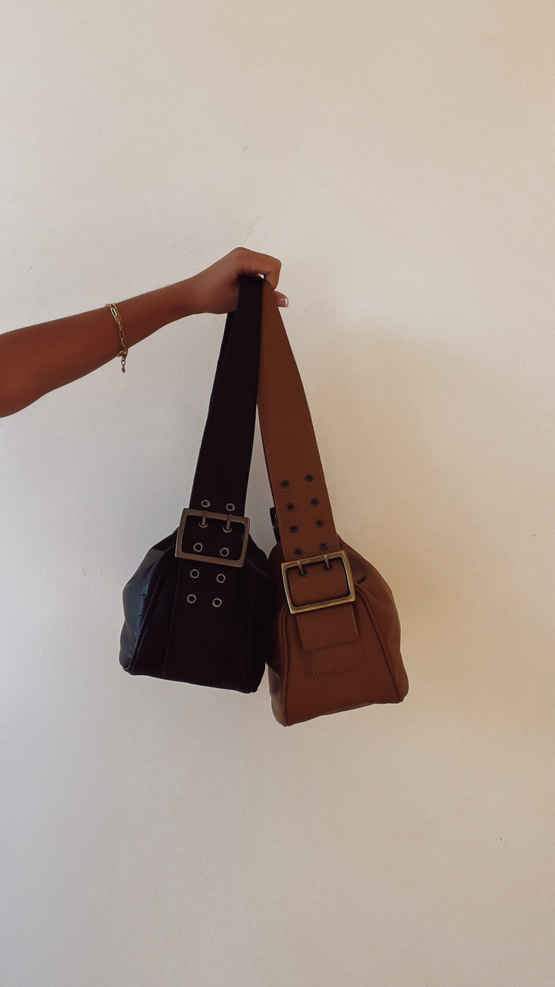 Two handbags, one black and one brown, held against a white background.