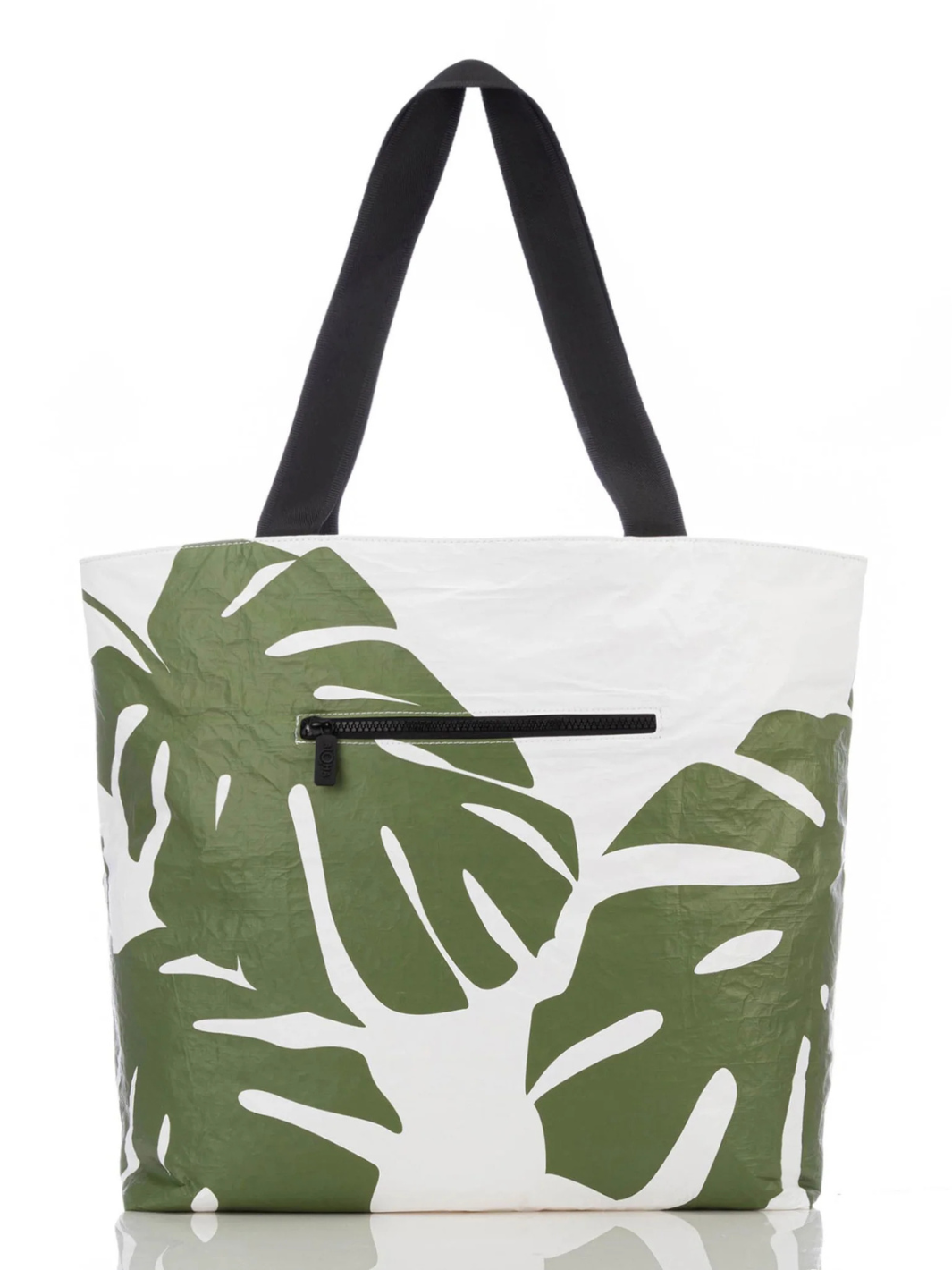 Aloha Collective Monstera Seaweed tote with white body, green monstera leaf print, black handles, front zip pocket.