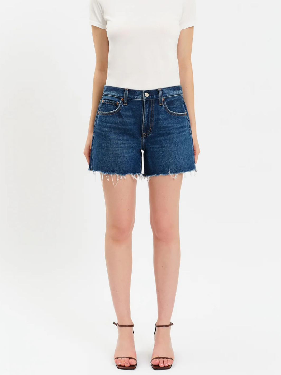 Daze Denim Crossroads mid-rise denim shorts with a loose fit and frayed hem on a model.