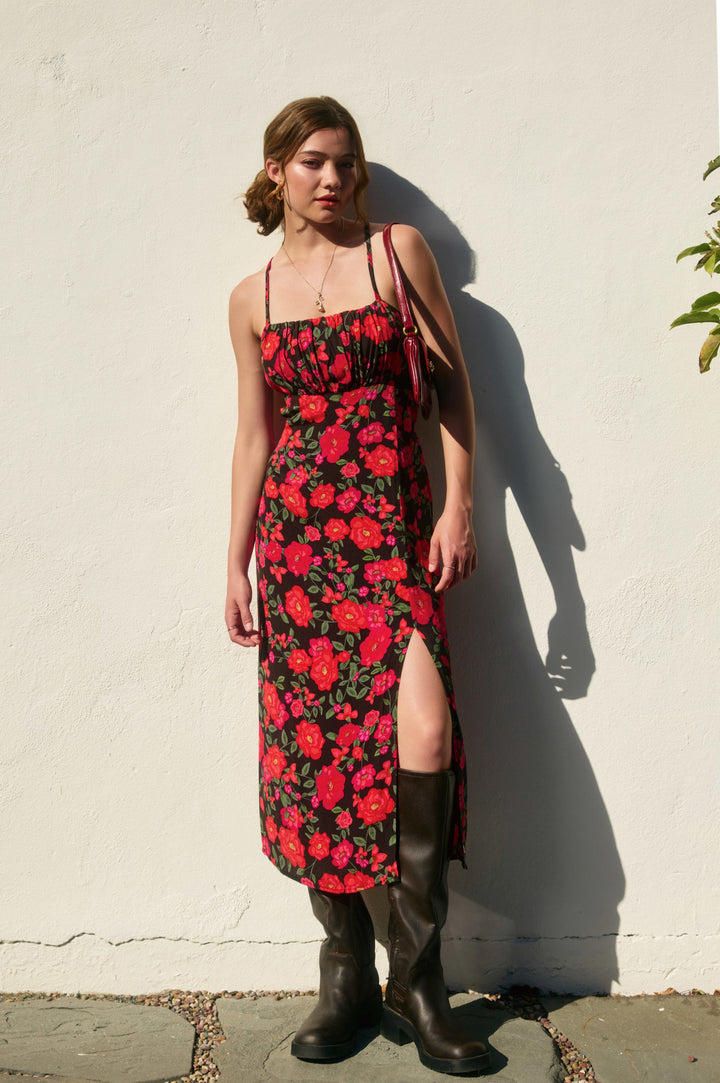 Stylish model showcases the Soraya Printed Floral Maxi Dress with vibrant red flowers, perfect for any occasion.