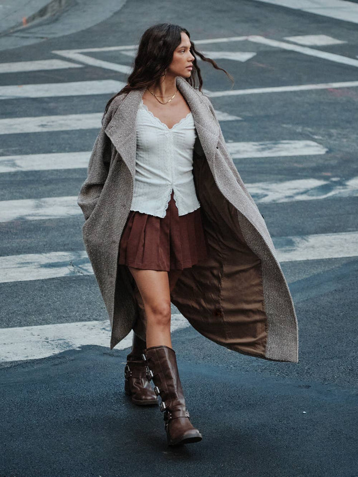 Juniper Lace-Trim Pointelle Sweater in Cream — walking view of fitted V-neck knit layered under a coat | Jayden P Boutique