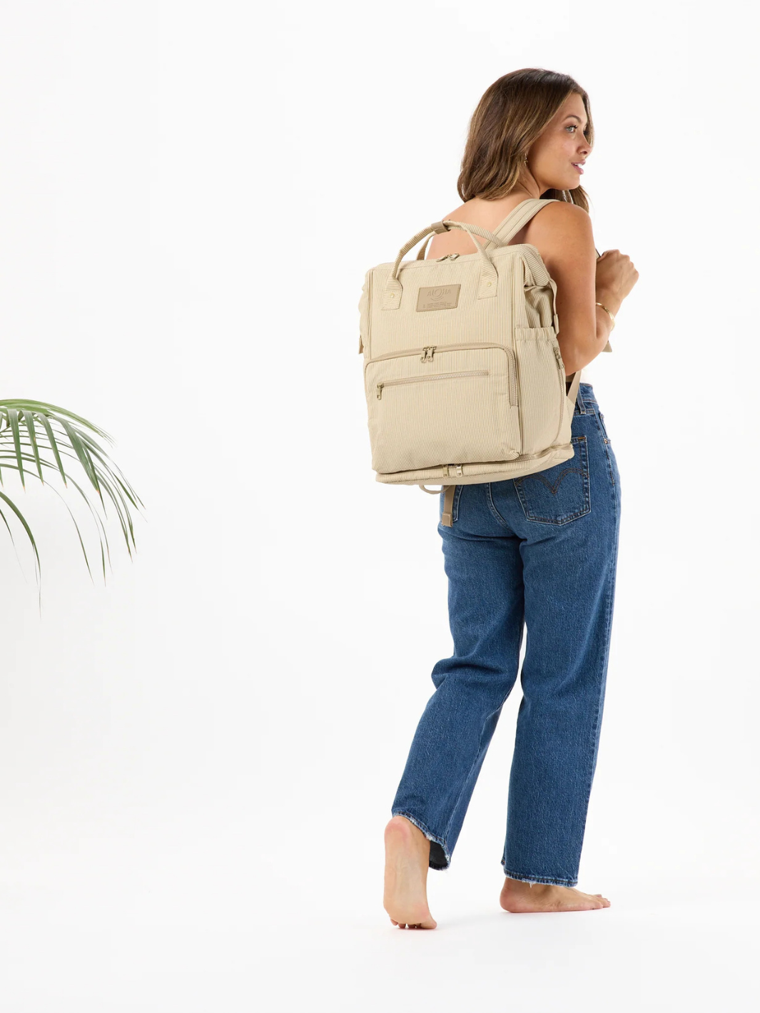 ALOHA Collection Le Bébé Diaper Backpack in beige worn by a person in jeans.