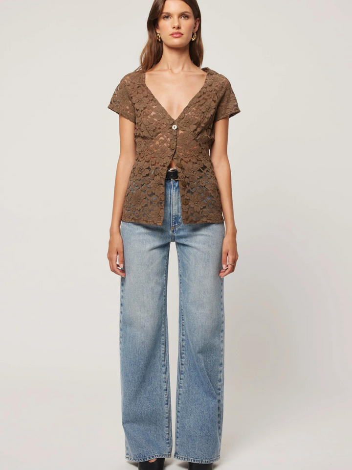 Stylish model wearing ROLLAS - Sailor Scoop Jeans paired with a chic top, showcasing a trendy look.
