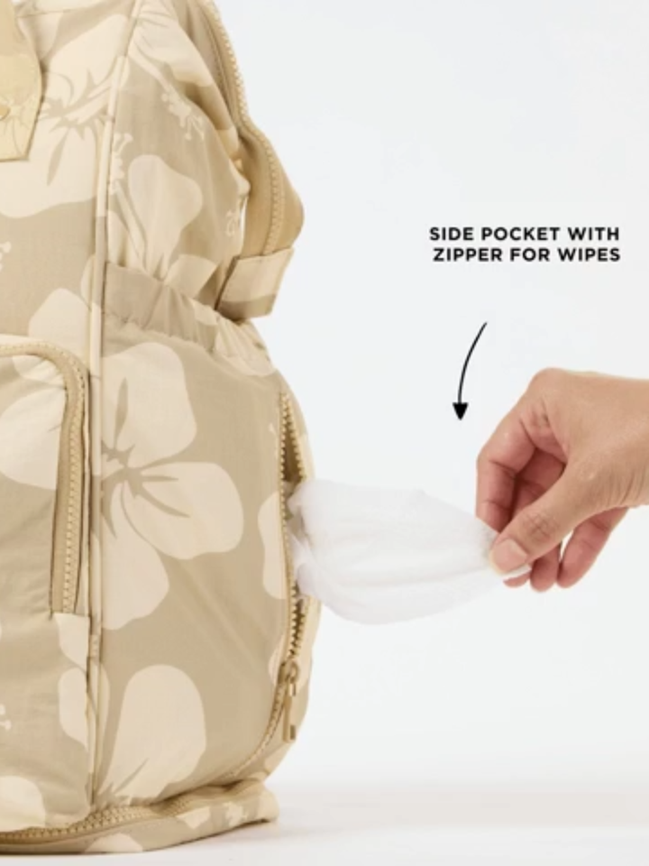 ALOHA Collection Le Bébé Diaper Backpack in beige floral print with a side pocket zipper for wipes.