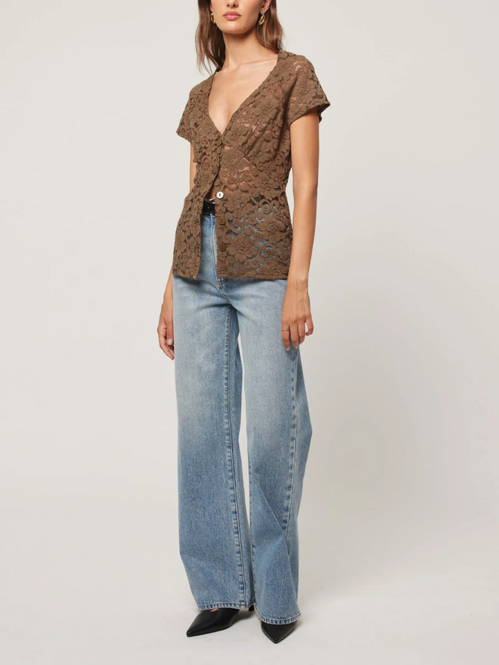 Stylish model showcasing ROLLAS - Sailor Scoop Jeans paired with a chic top for a trendy look.