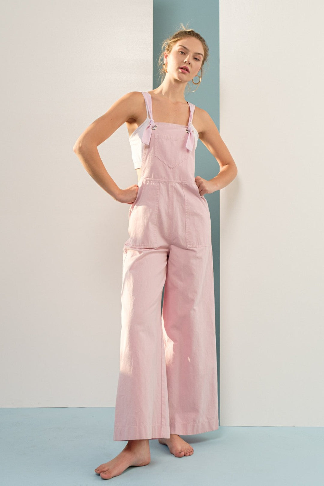 This on-trend jumpsuit is crafted from 100% cotton for unbeatable comfort. Its wide leg silhouette and tie straps add modern sophistication, while front and back pockets provide convenient storage. Complete your look with this timeless, versatile piece.