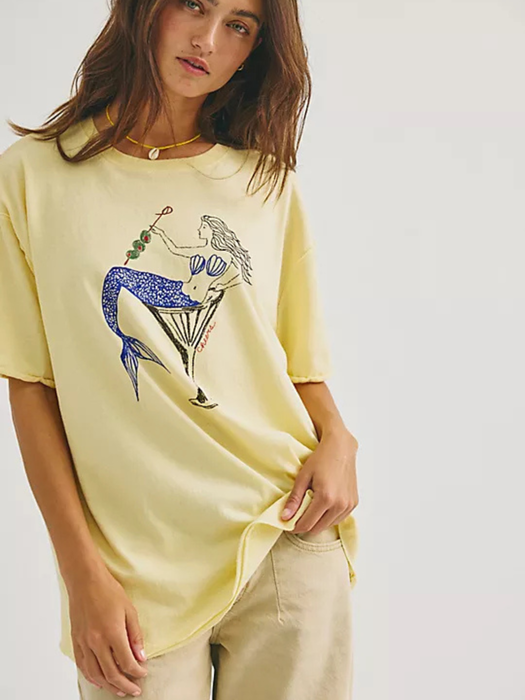 Oversized pale-yellow tee with mermaid and martini graphic from Free People We The Free Best Coast collection.