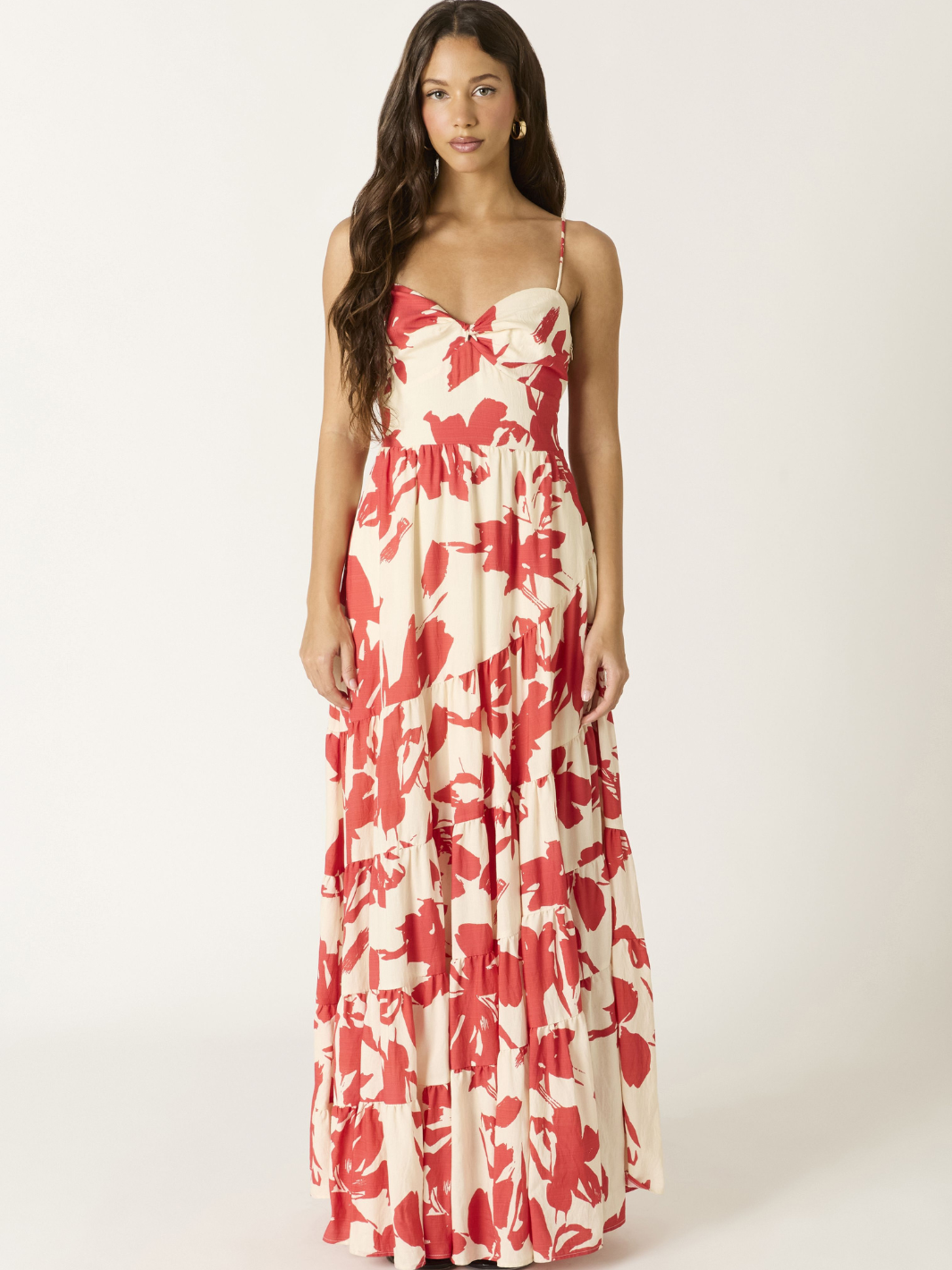 Crimson Bloom Tiered Maxi Dress on a model; cream base with bold red floral print, spaghetti straps, tiered length.