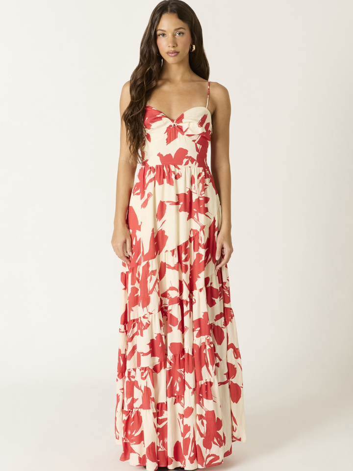 Crimson Bloom Tiered Maxi Dress on a model; cream base with bold red floral print, spaghetti straps, tiered length.
