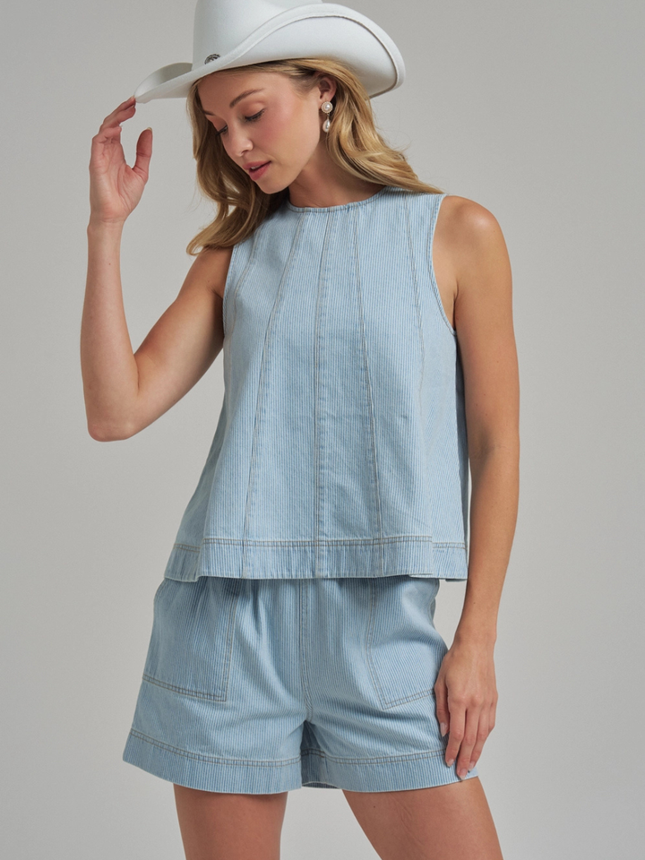 The Sutton Pinstripe Denim Shorts in light denim with panel seams, shown with a matching top for a casual yet tailored summer look.