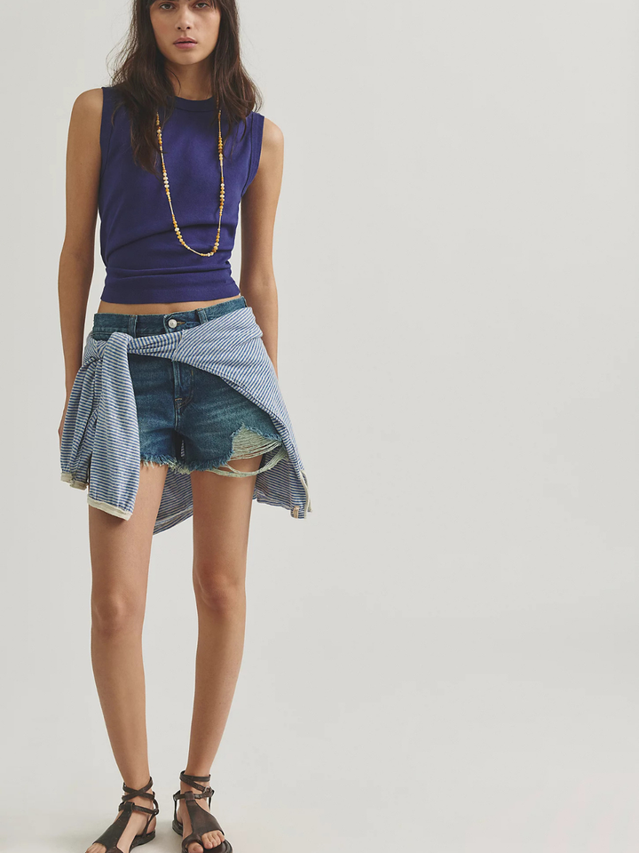 Free People Now Or Never Denim Shorts on a model with a purple sleeveless top and striped shirt tied around the waist.