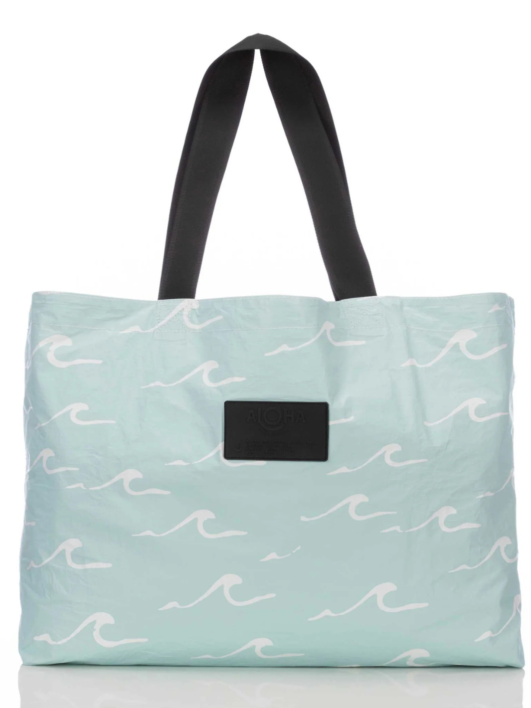 Seaside bag from ALOHA COLLECTION in light aqua with white wave pattern, black handles, ALOHA label.