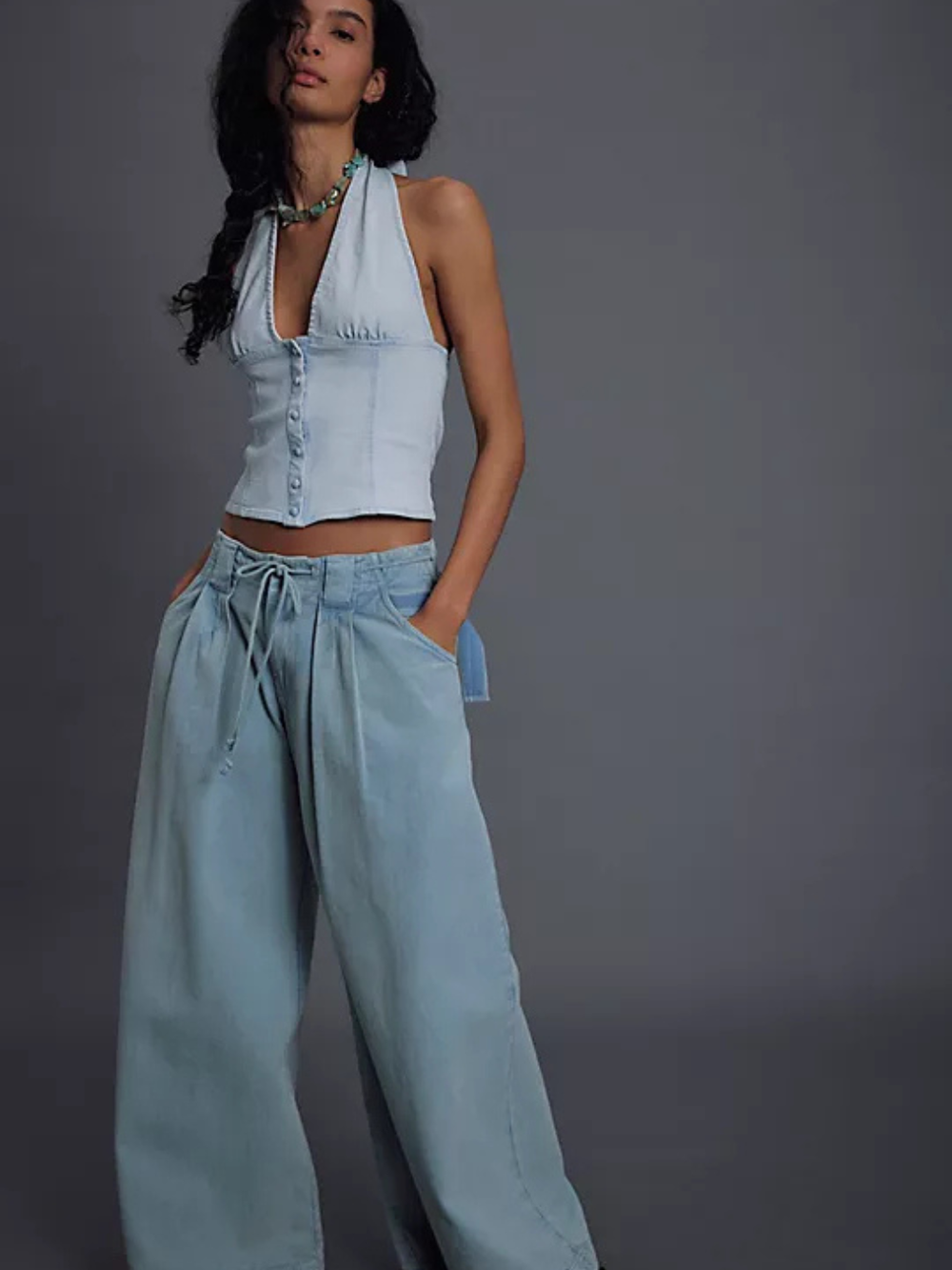 Ramona Denim Halter Top in light wash on model with corset-inspired seaming, paired with wide-leg denim pants.