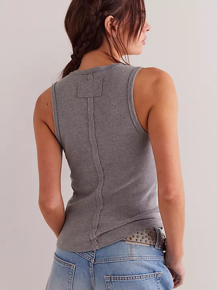 Back view of a gray Neria Tank Top with a center seam and back patch, worn with light denim jeans.