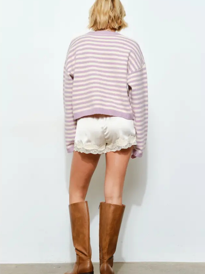 Back view of model wearing Midnight Muse Satin Shorts with lace trim and brown knee-high boots.