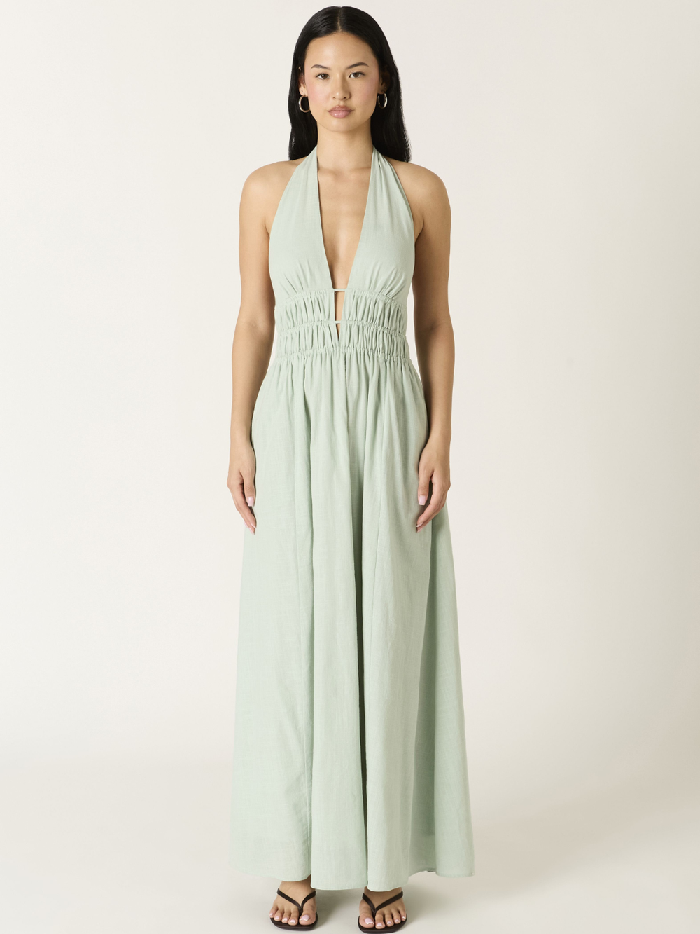 Soleil Plunge Halter Maxi Dress in sage green with deep V neckline, ruched waist, and flowing A-line skirt.
