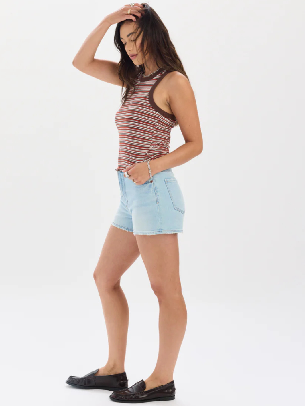 Model wearing DAZE DENIM Troublemaker High Rise Denim Shorts in light wash with striped top.