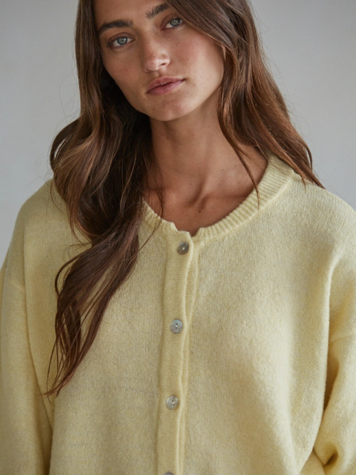 Sunday Soft Button-Front Knit Cardigan in pale yellow, relaxed cropped fit, crew-neck with pearl buttons on model.