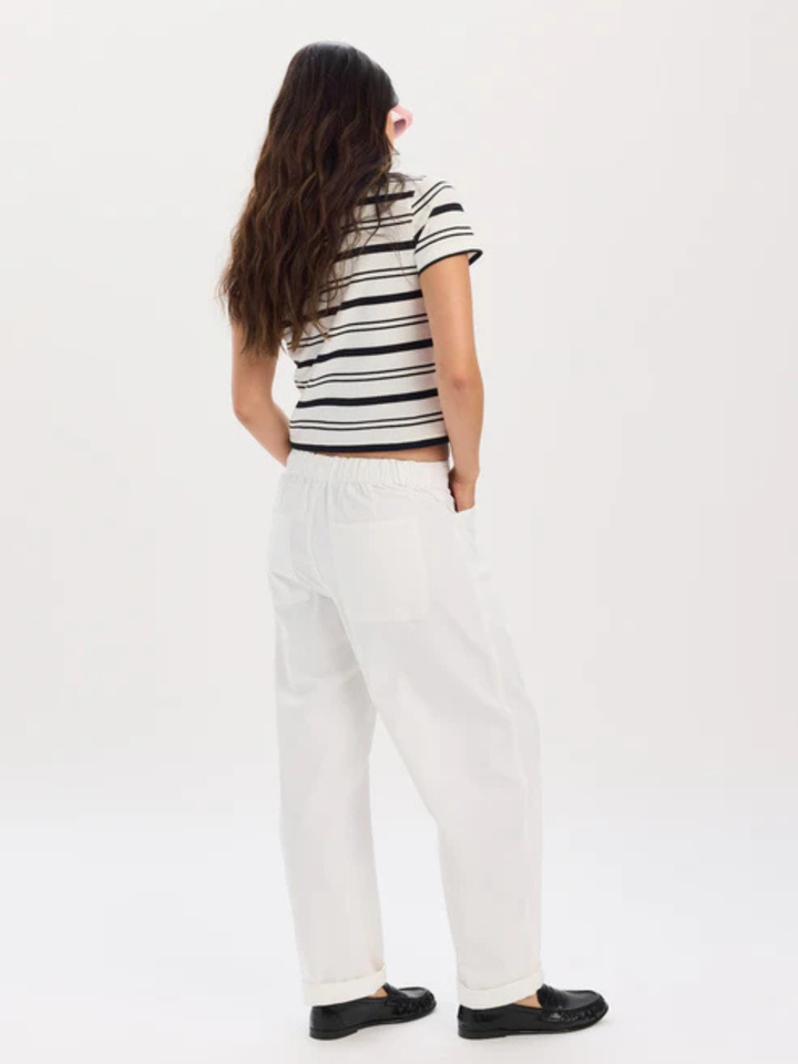 Back view of model wearing Daze Denim Villa Drawstring Barrel Leg Pant with striped tee.