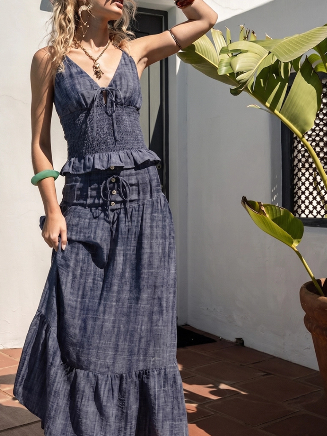 Indigo Dreams high-waist smocked denim maxi skirt with tiered ruffle hem, drawstring and button details.