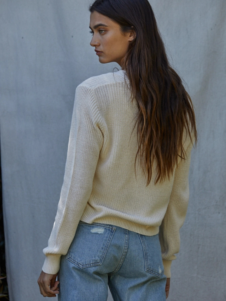 Back view of model in cream open-knit Golden Hour V-Neck Button-Front Knit Cardigan over denim, relaxed cropped fit.
