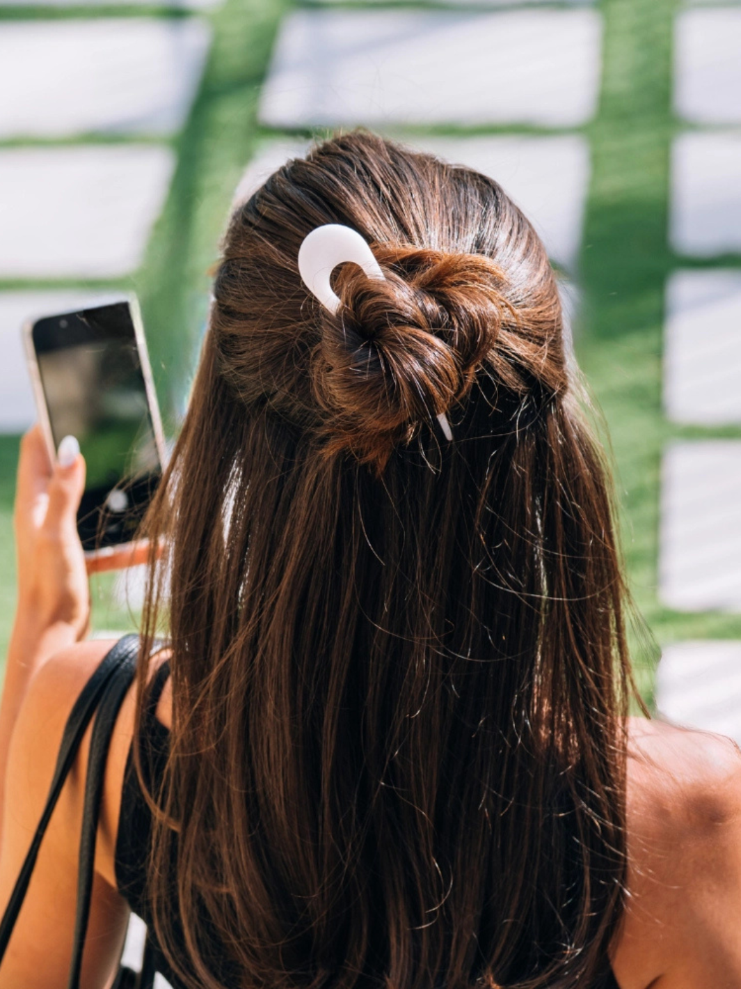 Back view of woman with brown hair in a bun secured by TELETIES French Hair Pin.