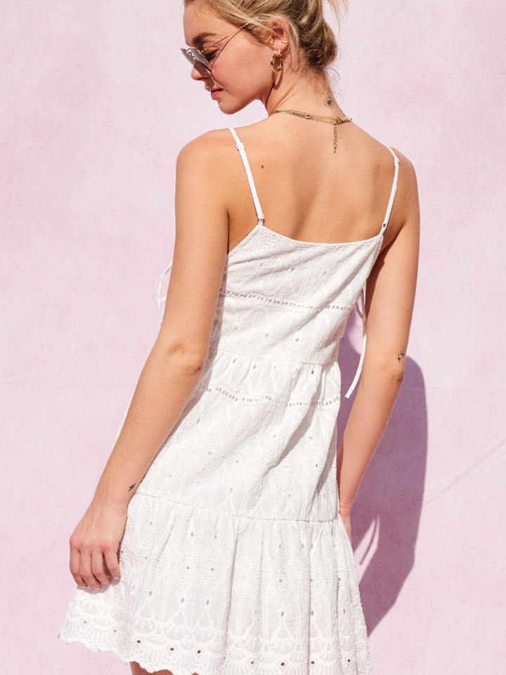 Sweet Escape Eyelet Mini Dress in white, back view on model with thin straps and delicate eyelet pattern.