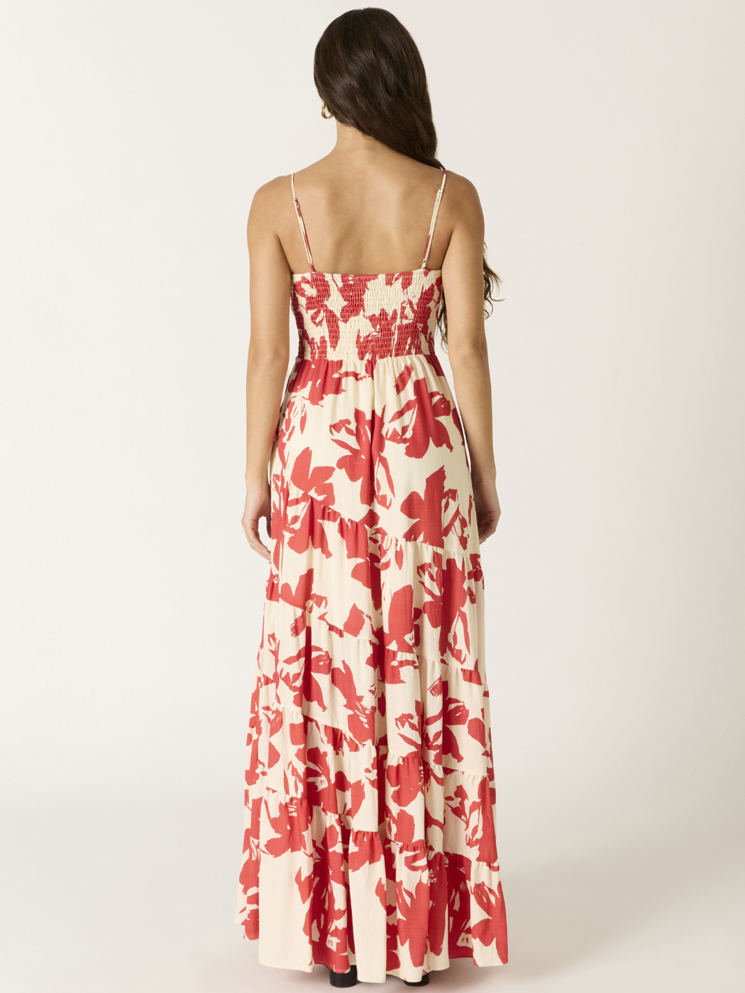 Back view of a model in Crimson Bloom Tiered Maxi Dress with red floral print on cream, spaghetti straps.