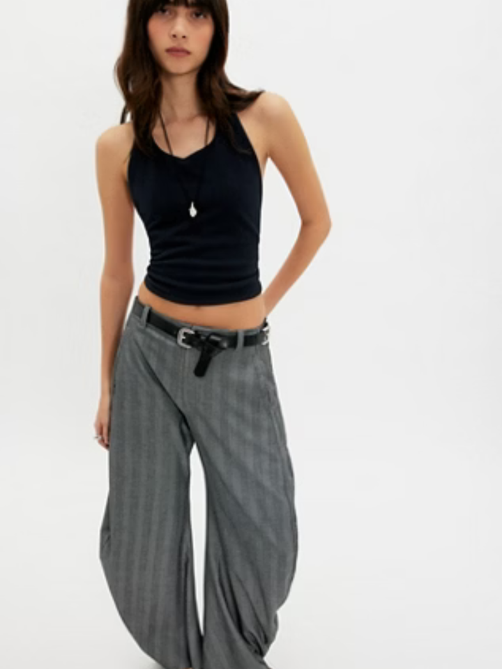 Free People Round Two Pique Low-Back Tank in black with knotted back detail, styled with gray pinstripe wide-leg pants.