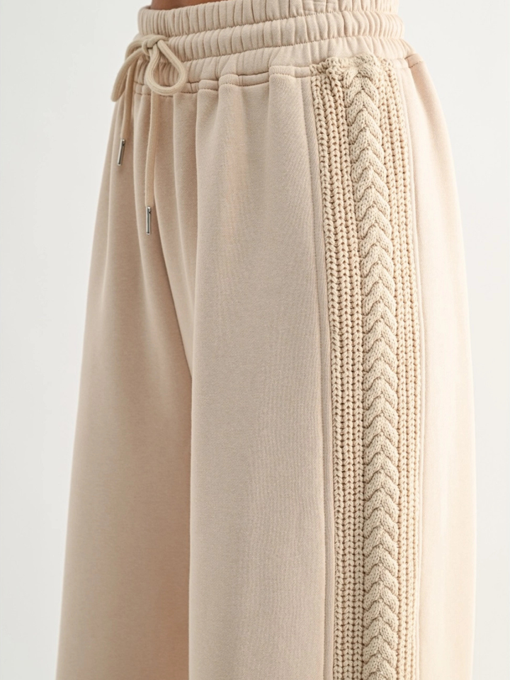 Beige lounge pants with a braided cable-knit side stripe and drawstring waist, inspired by Aria Cable Knit Sweatshirt.
