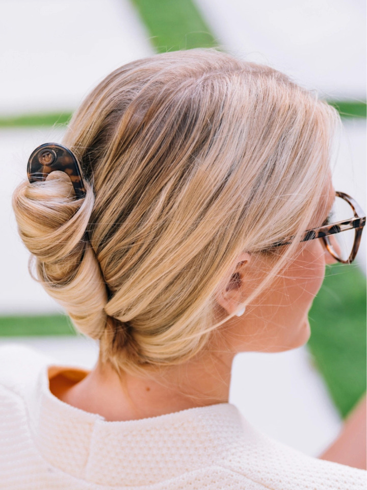 Blonde woman wearing tortoiseshell TELETIES French Hair Pin securing a polished bun.