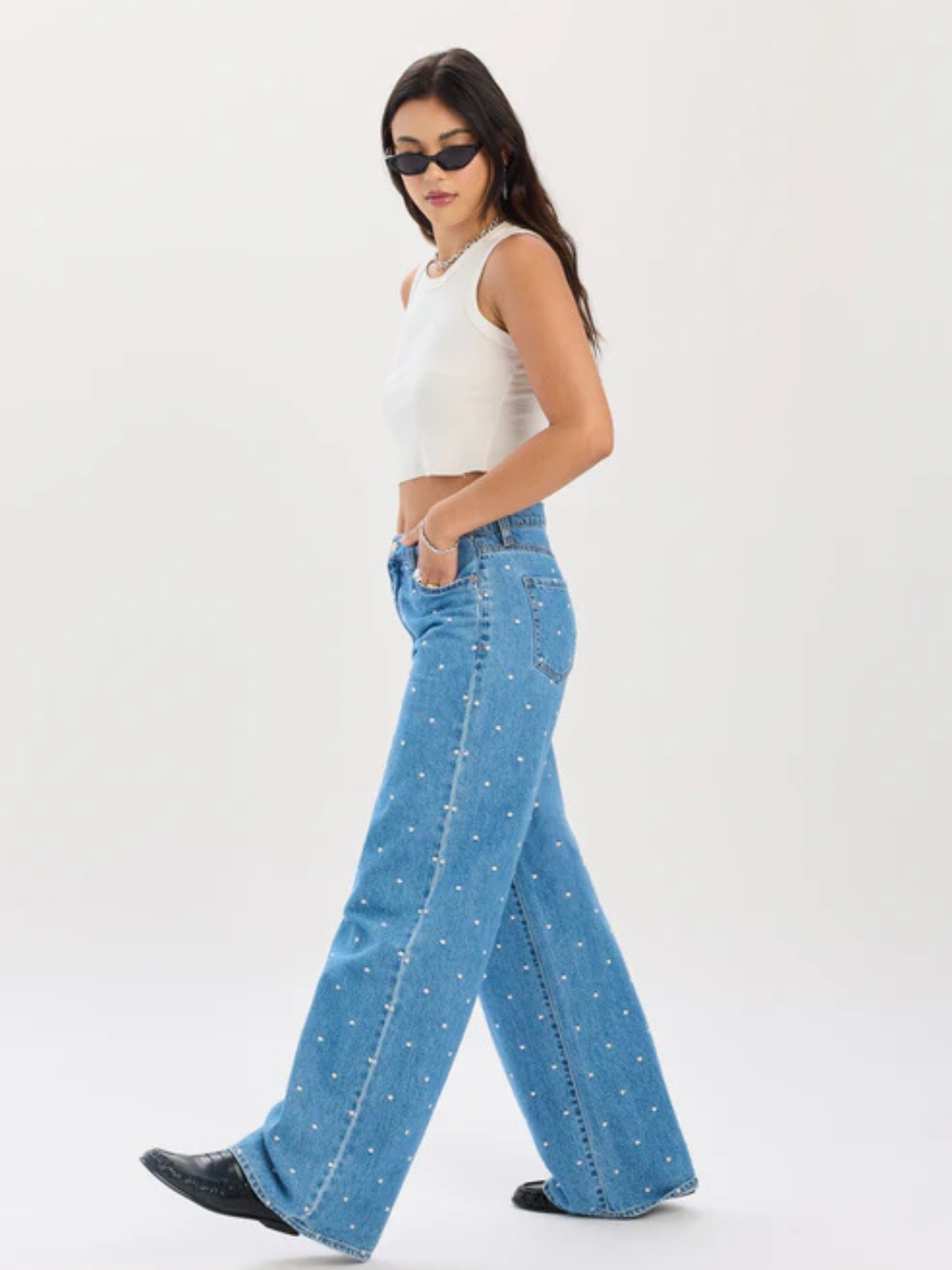 Daze Denim The Wanderer mid-rise palazzo jeans with pearl studs, worn by a model in a white crop top and sunglasses.