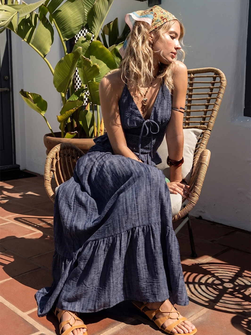 Model in Indigo Dreams high-waist smocked denim maxi skirt with tiered ruffle hem and tie detail.