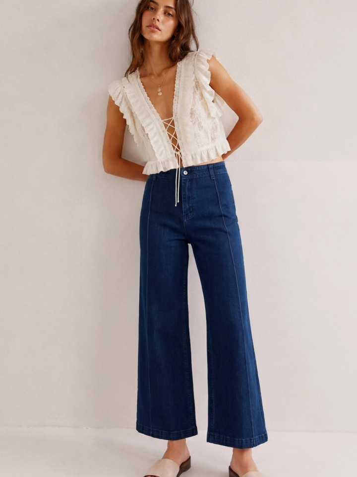 Model wearing The Sundaze Dark Indigo High-Rise Wide-Leg Stretch Jean with a white lace-up top.