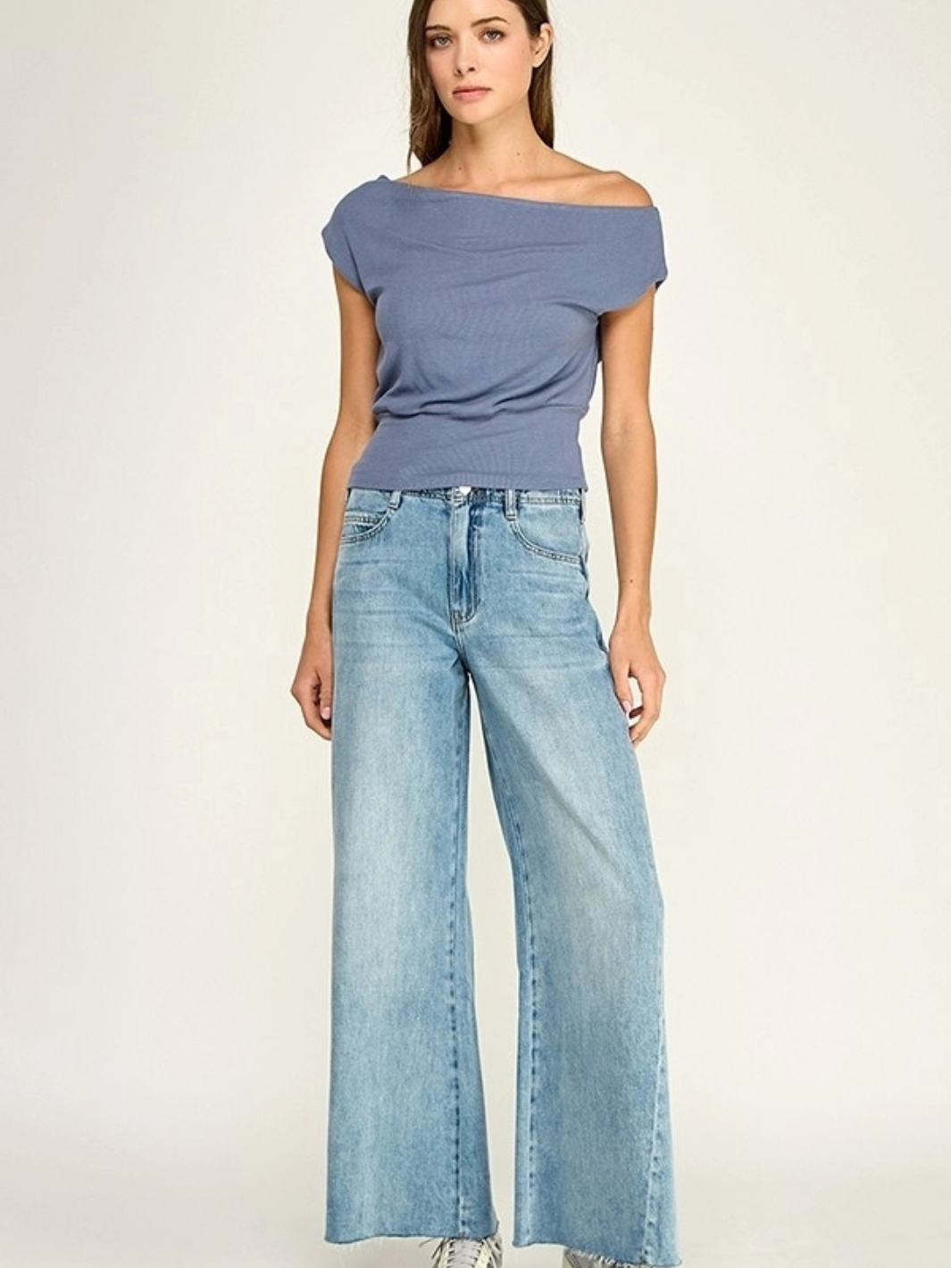Malibu Slate Blue Off-Shoulder Stretch Knit Top on model, paired with light-wash wide-leg jeans.