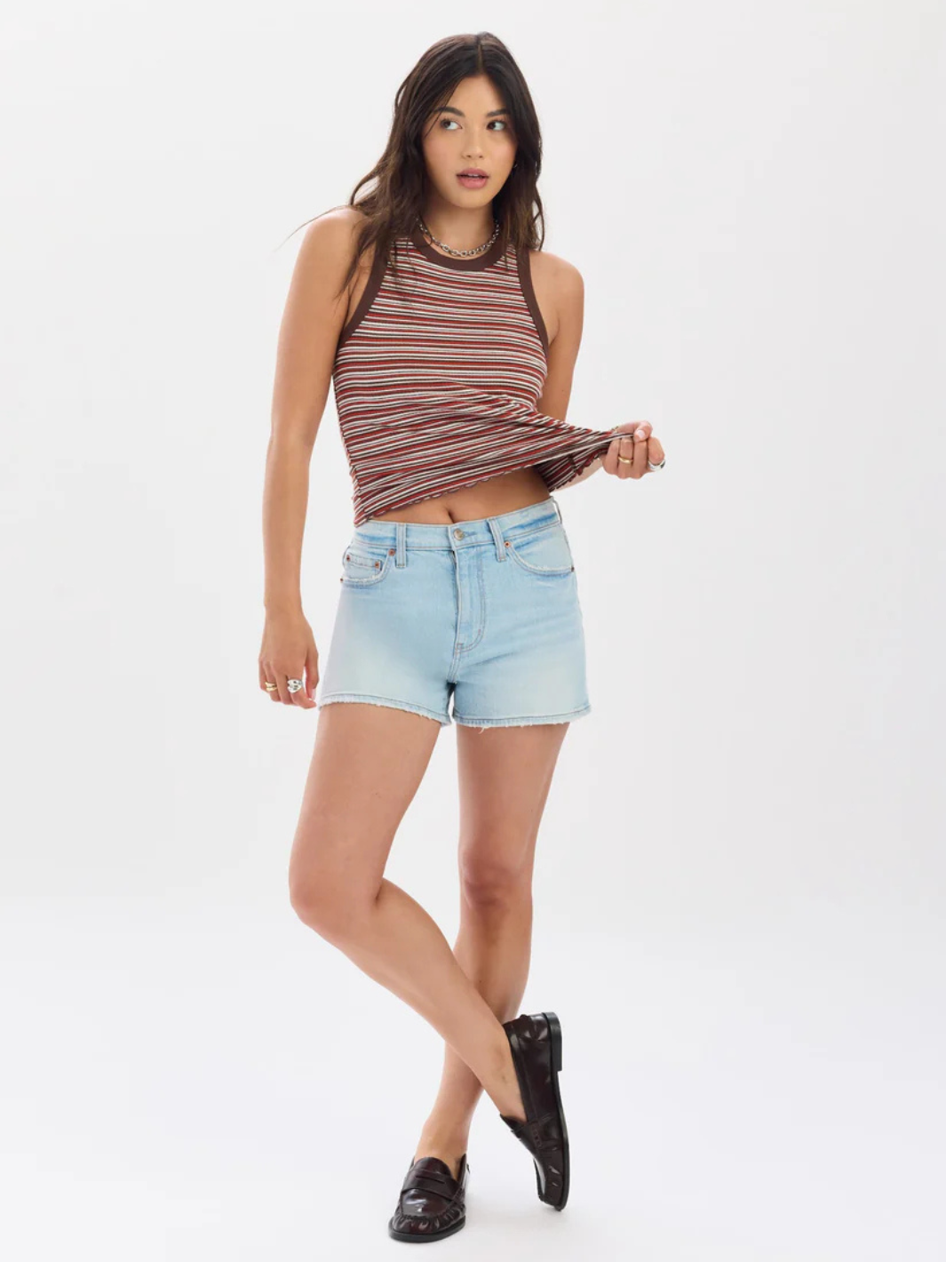 Model wearing DAZE DENIM Troublemaker High Rise Denim Short with a striped top and loafers.