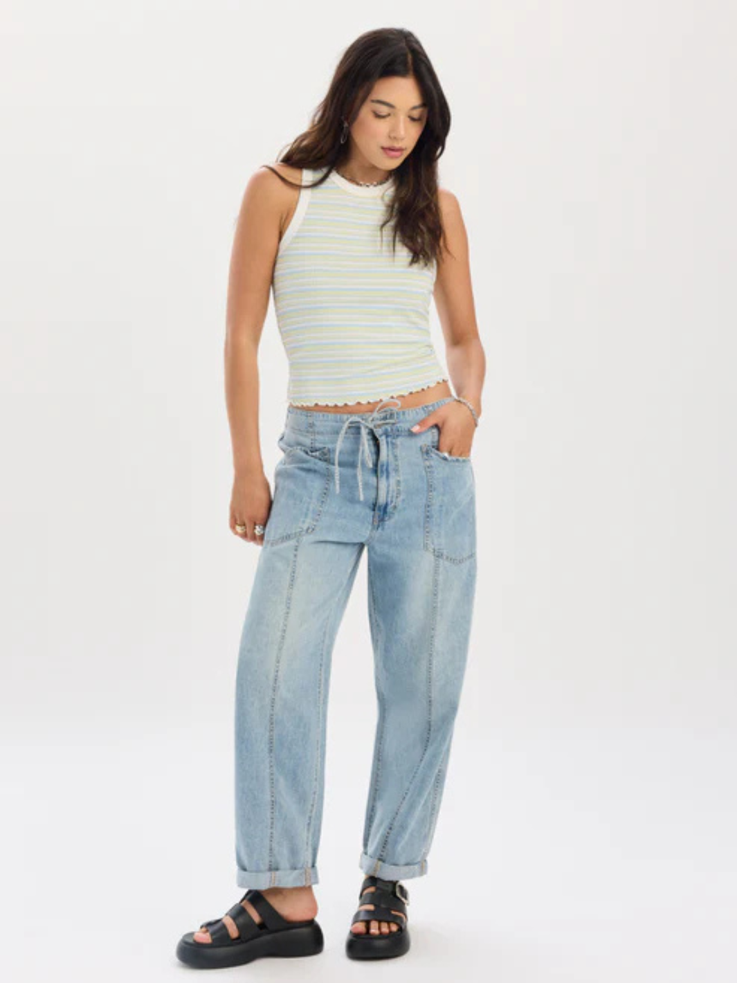 Model wearing light-wash Daze Denim Villa Drawstring Barrel Leg Pant with a drawstring waist and a striped top.