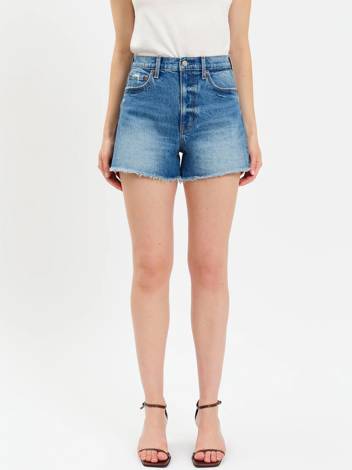 Daze Denim The Knockout High Rise A-Line Shorts in distressed blue denim with a frayed hem.