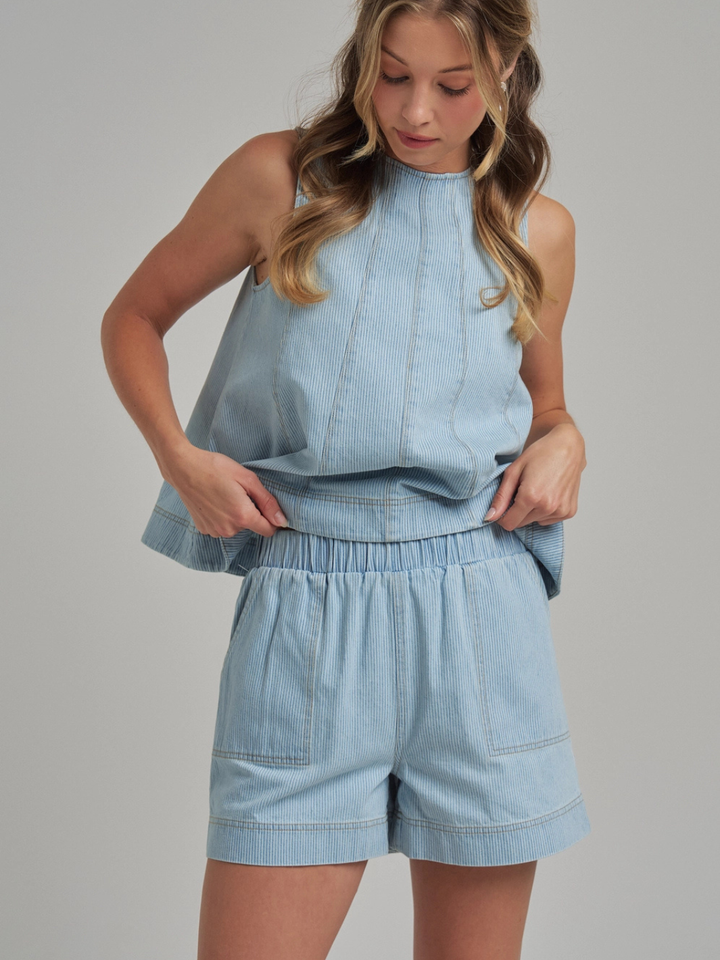 The Sutton Pinstripe Denim Tank Top on a model, structured sleeveless light-blue denim with panel seams.