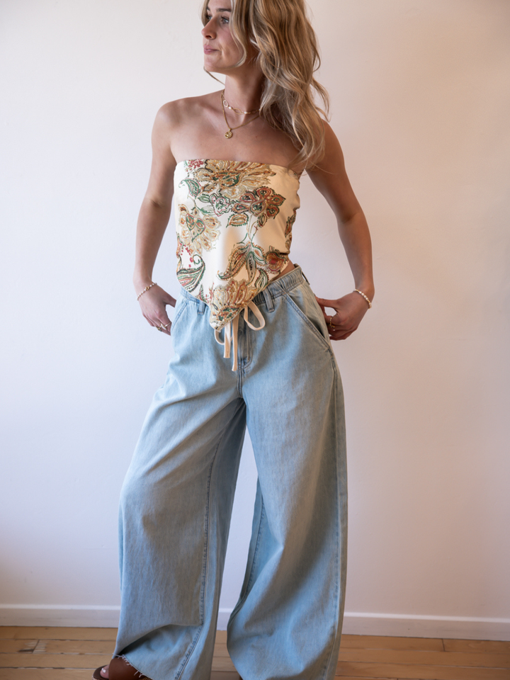 Model in floral tube top with light-wash Daze Denim Cabana Wide Leg Pull On Jeans, drawstring waist.