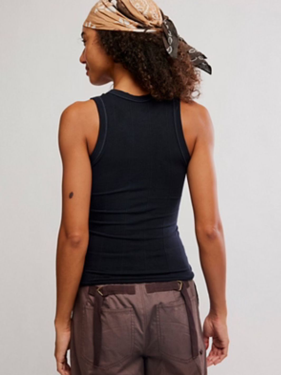 Back view of a model in a black Free People So Soft Seamless Modal Tank, sleek fitted base layer.