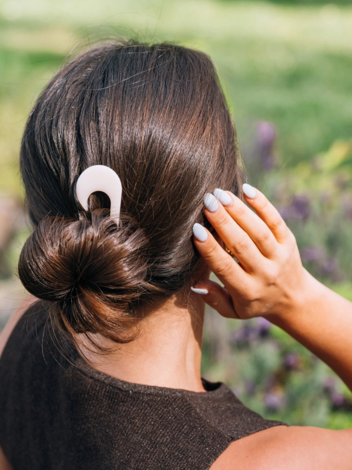 Brunette bun secured with pale pink TELETIES French Hair Pin.