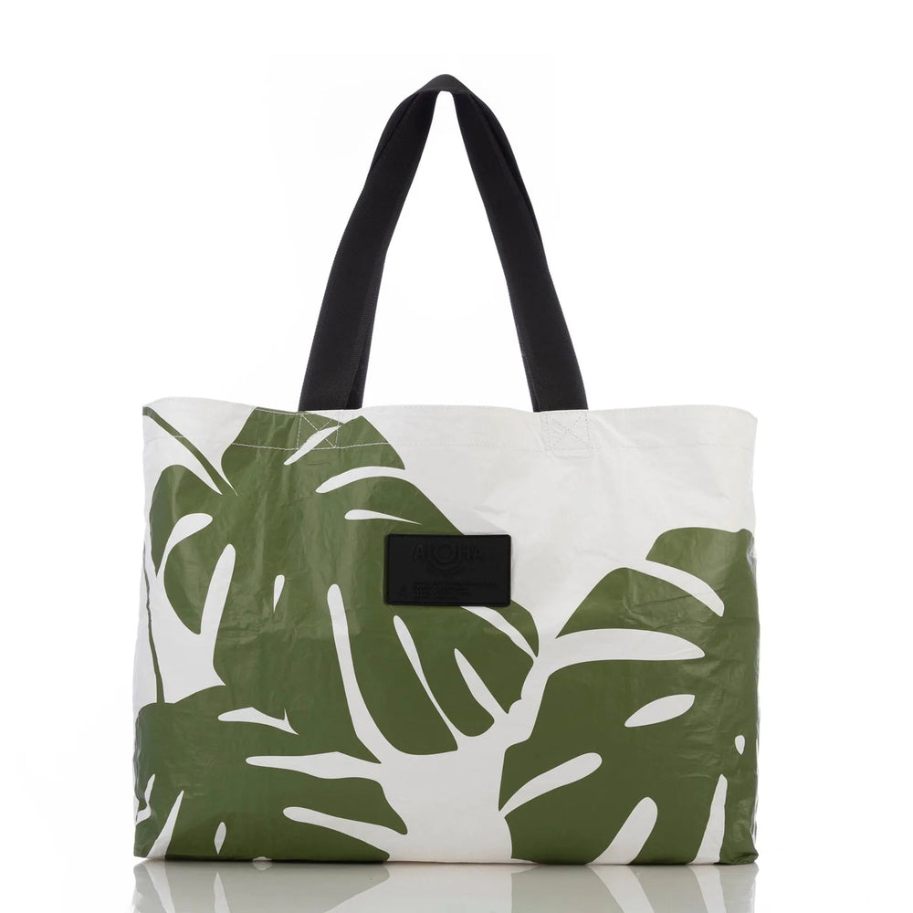 Aloha Monstera Seaweed tote with tropical green Monstera leaf print and black handles.