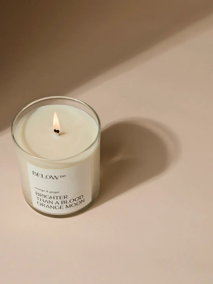 Below 60- Brighter Than A Blood Orange Moon candle glows with orange-ginger notes and soft florals.