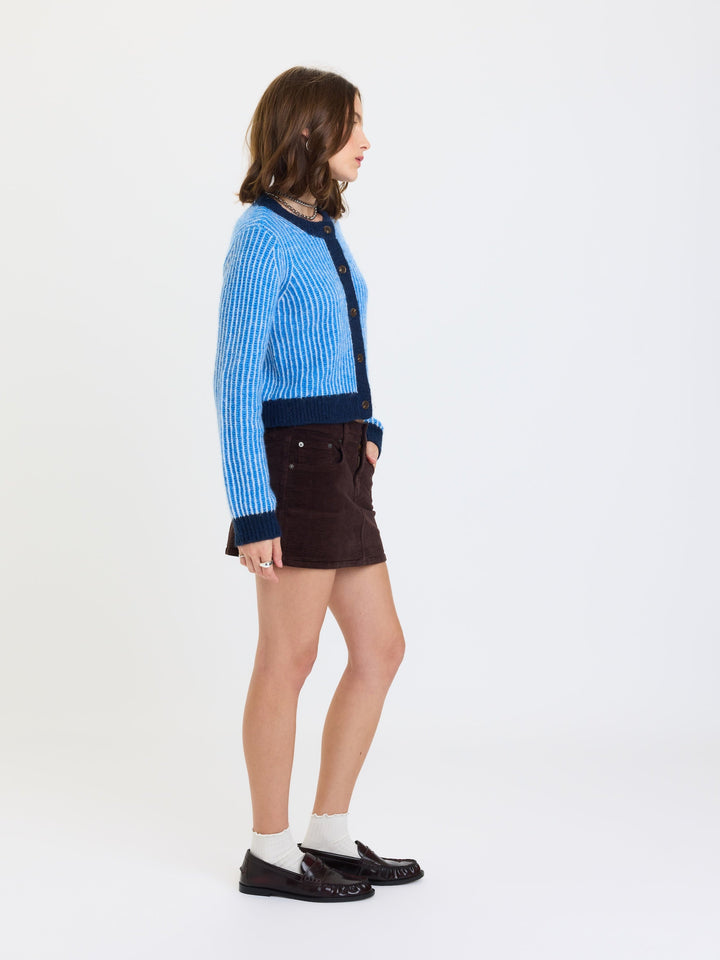 Daze Denim Fever Corduroy Micro Mini Skirt in Chocolate — three-quarter side view with knit cardigan | Jayden P Boutique