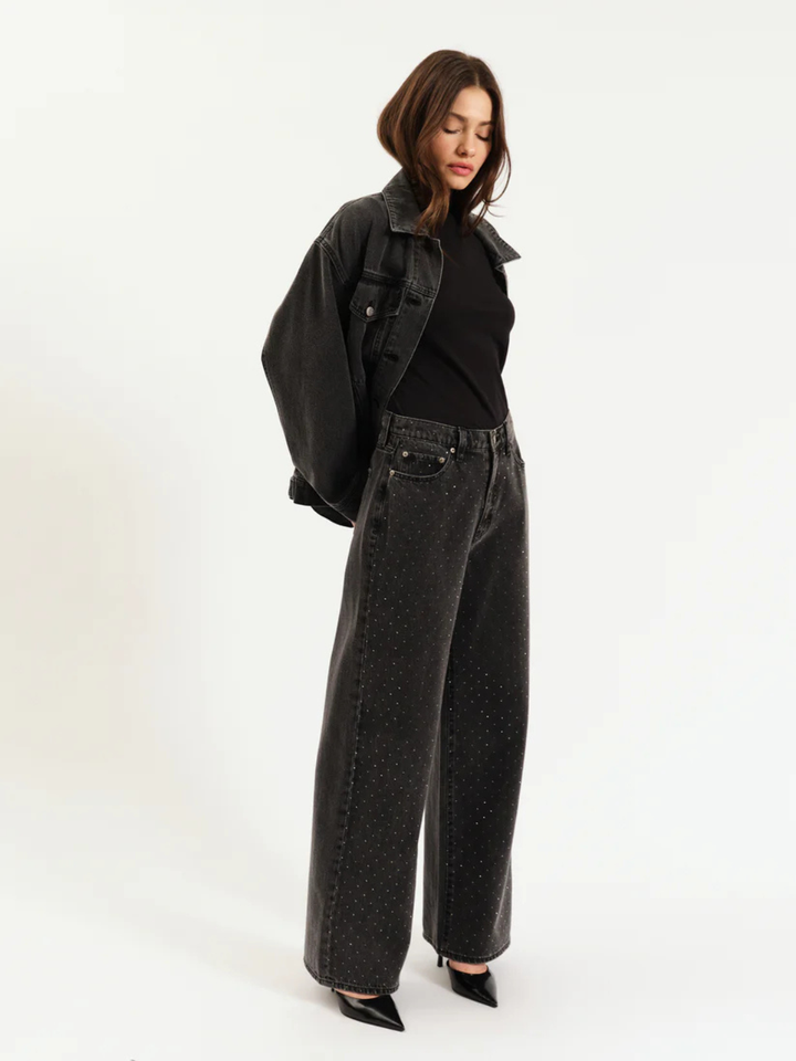 DAZE DENIM Far Out High Rise Wide Leg Jeans in dark speckled denim, styled with a black top and oversized jacket.