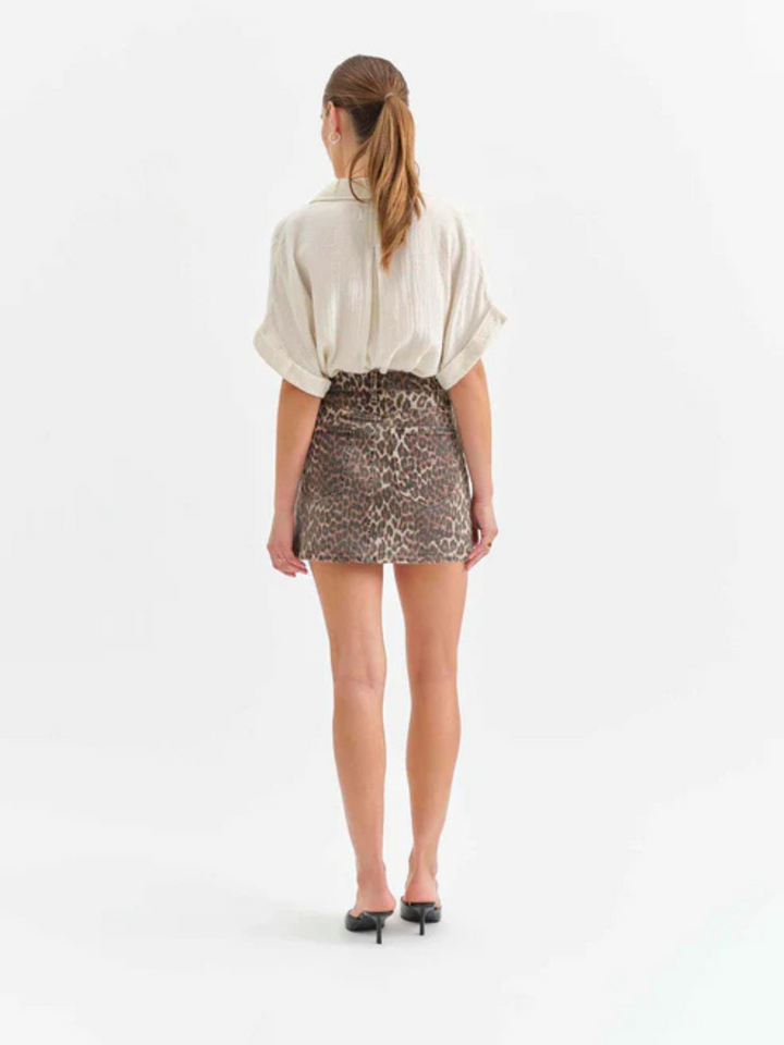 Stylish back view of a model wearing the DAZE DENIM - Malibu Mini Denim Skirt with a chic cheetah print.