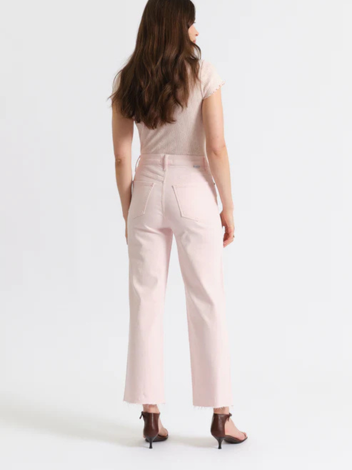 Back view of blush pink DAZE DENIM Pleaser high-rise, wide-ankle jeans with back pockets and raw hem.