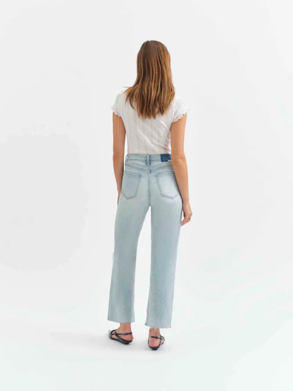 Stylish woman wearing DAZE DENIM - Pleaser in Charisma Distressed High Rise Wide Ankle Jeans from behind, showcasing vintage flair.