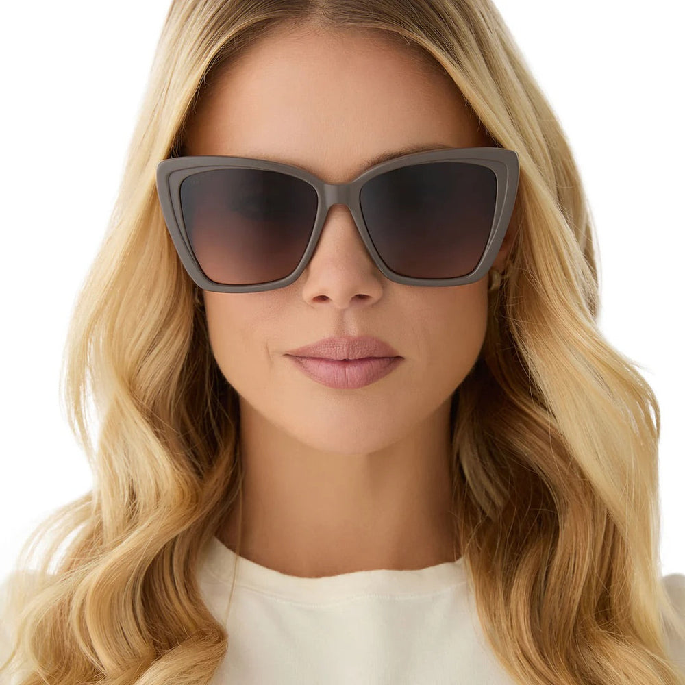 Cat-eye sunglasses with tinted lenses on a white background.